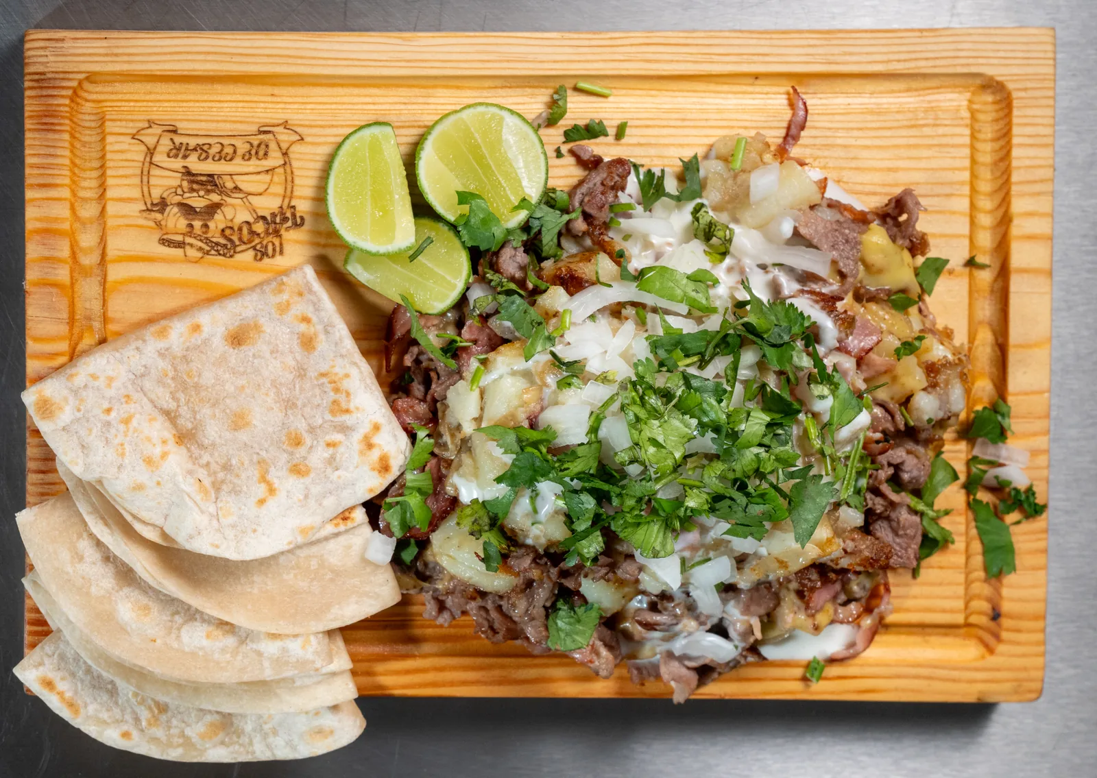 Tacos servidos con cebolla, cilantro y limones